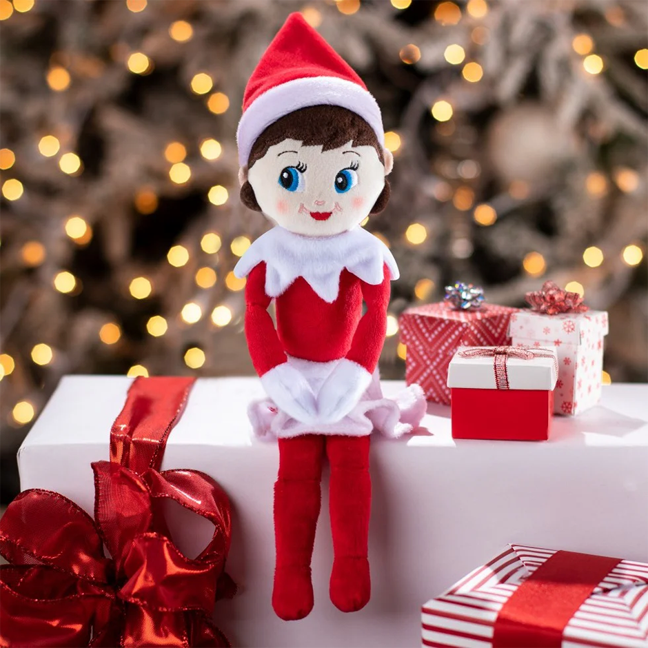 Elfo en la estantería con traje rojo y blanco, sentado junto a regalos